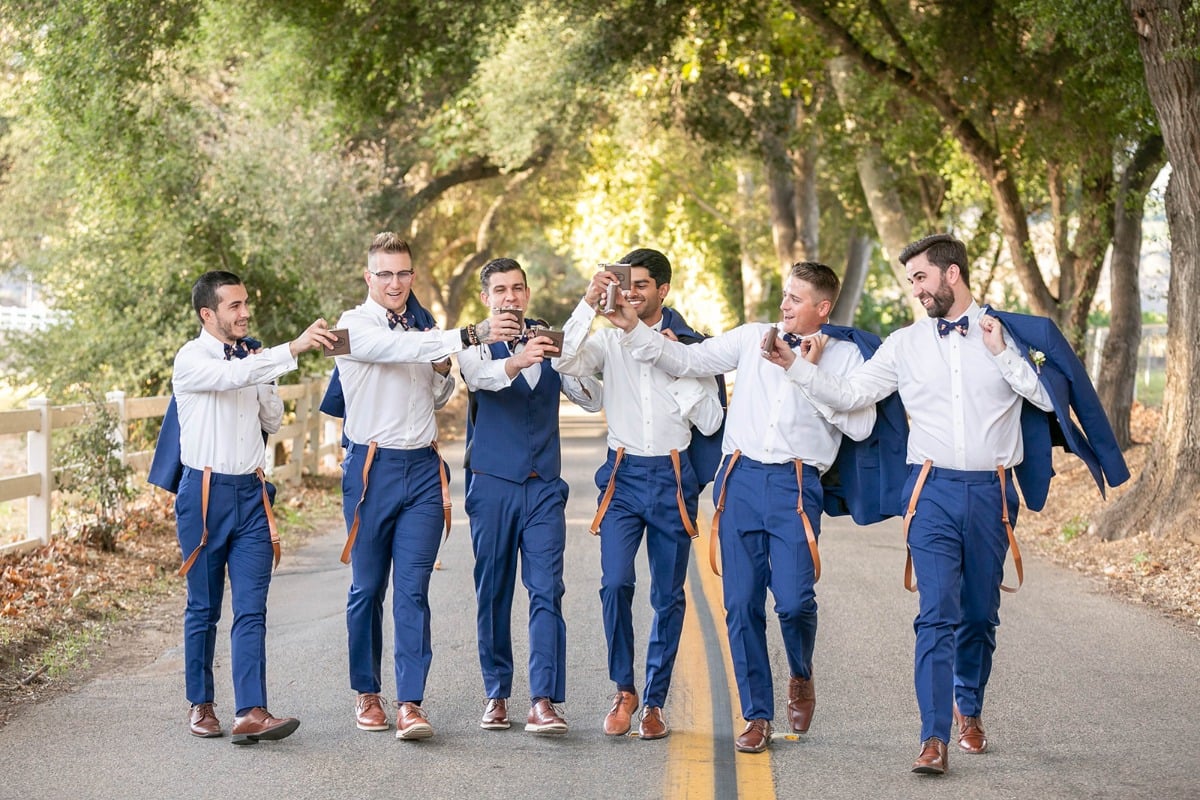 groom and his groomsmen in blue suits and suspenders