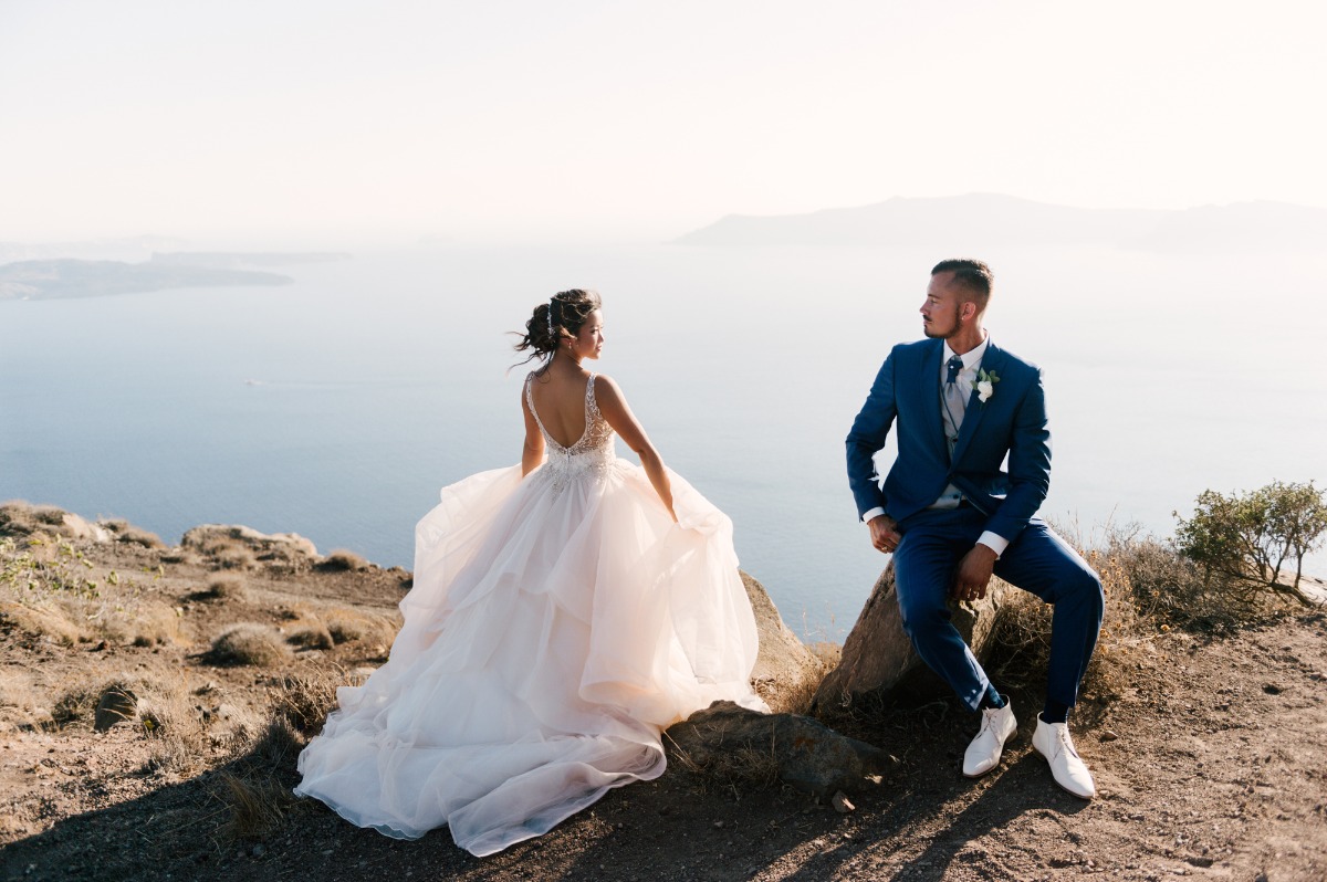 Bride and groom overlooking ocean on their wedding day, scenic view