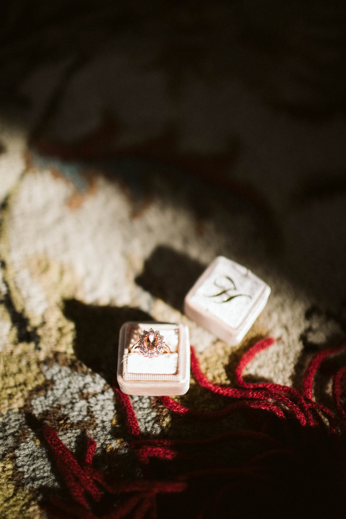 Engagement ring in velvet box on a textured surface