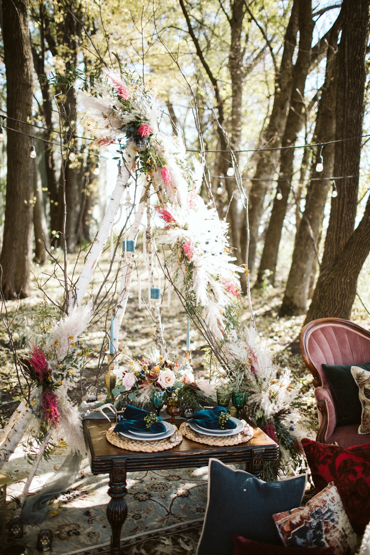 Boho wedding table setting in the woods with floral arch