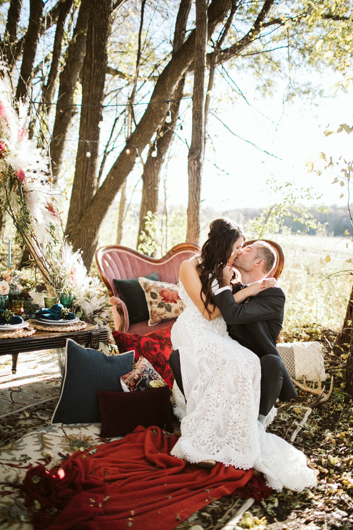 Bride and groom kissing at a whimsical outdoor wedding
