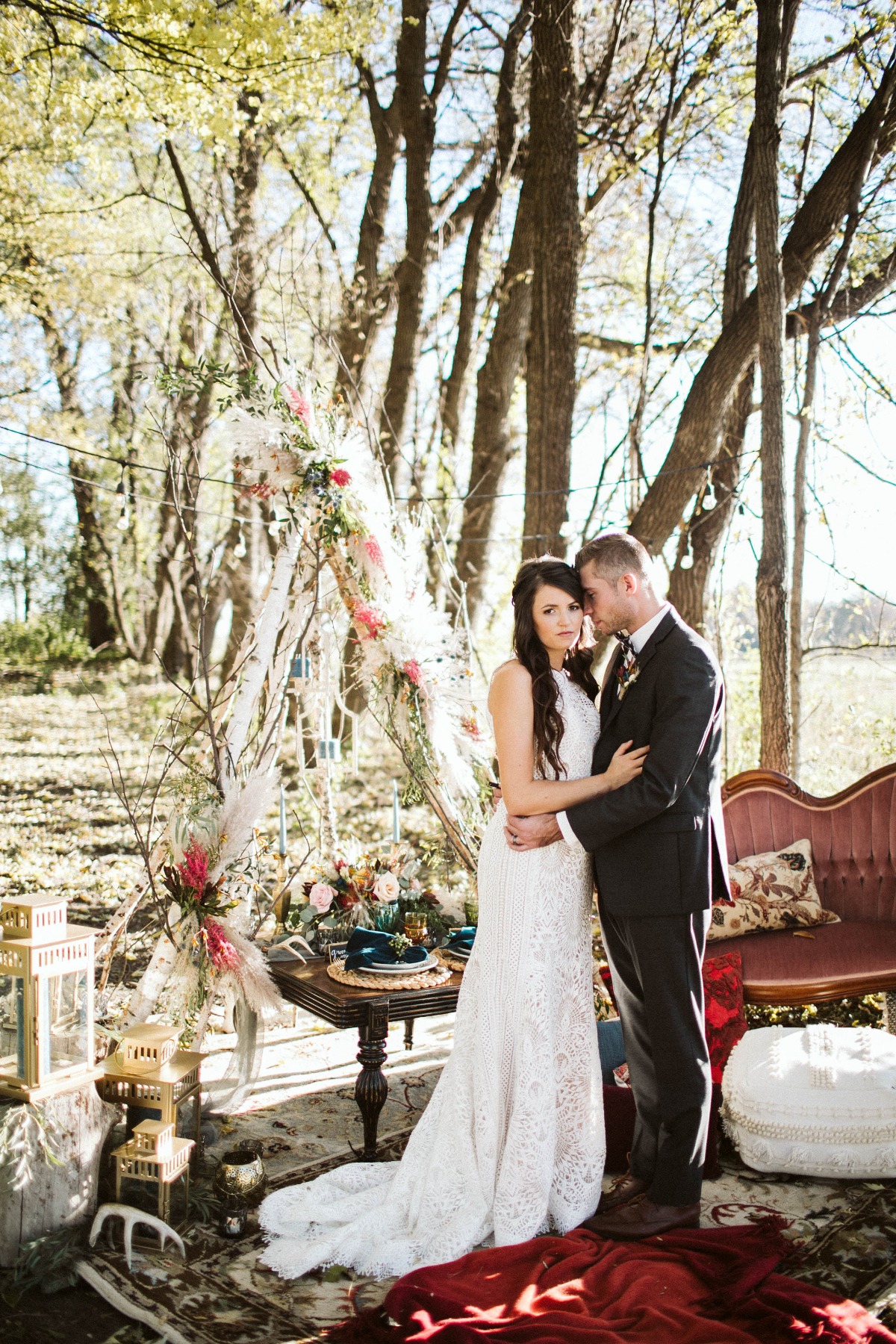Bride and groom embrace at boho chic outdoor wedding