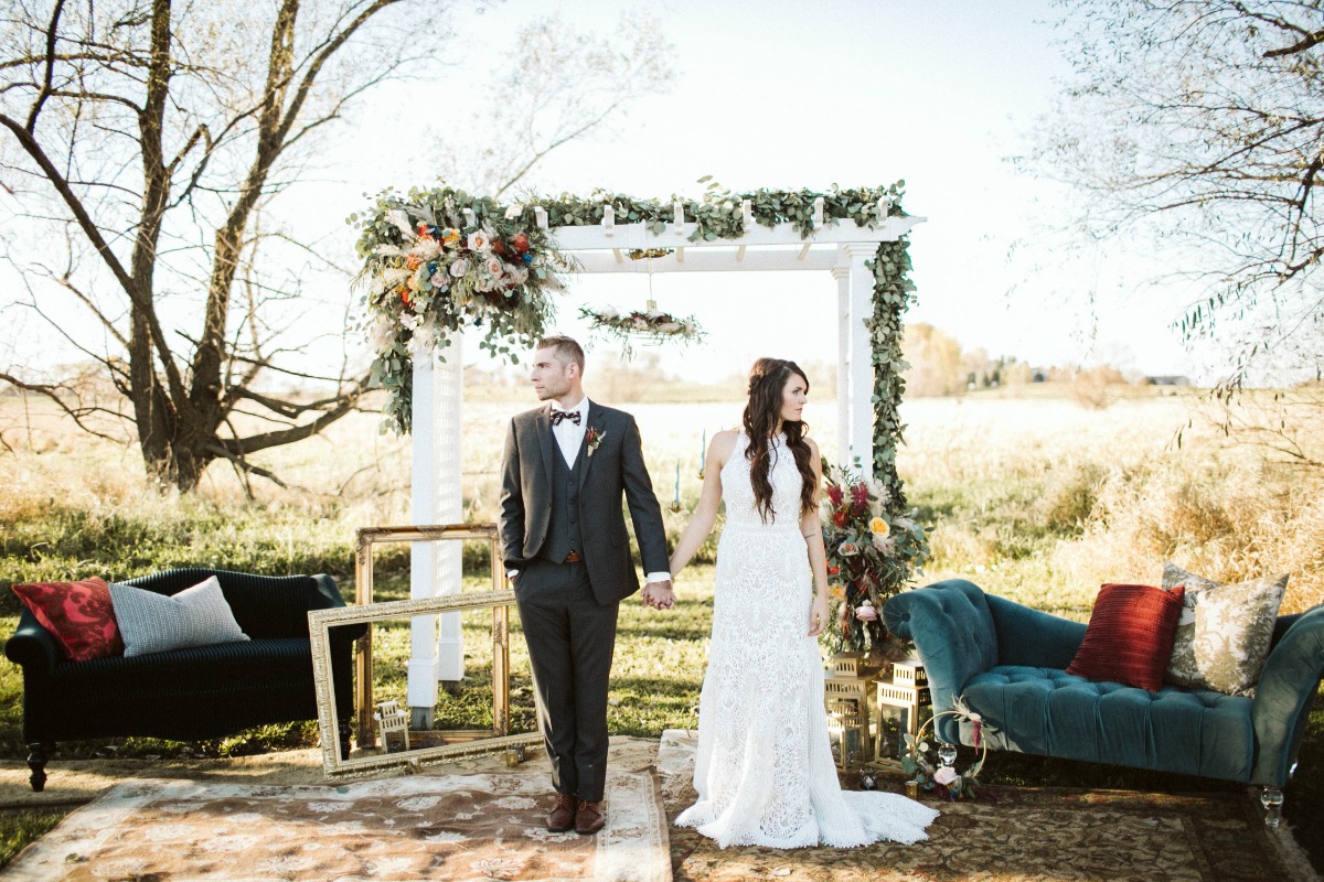 Bride and groom hold hands at outdoor wedding altar