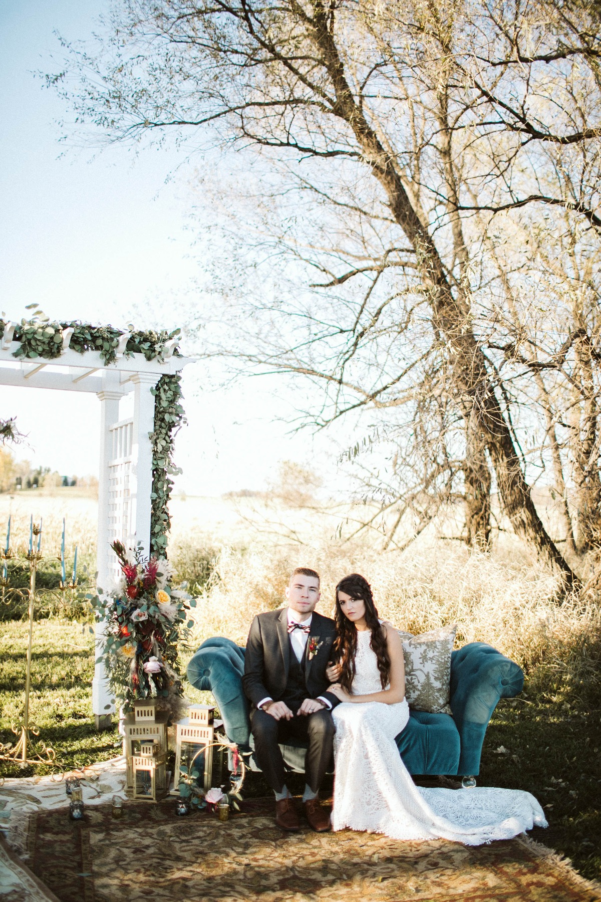 Bride and groom on a couch at their outdoor wedding