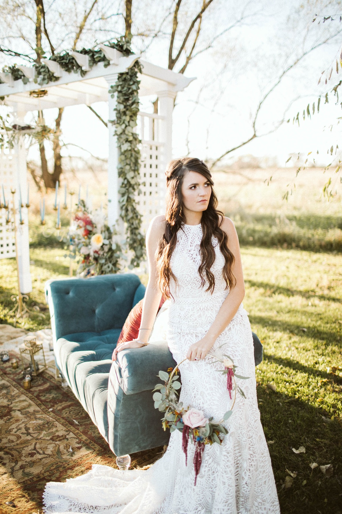 Bride in lace dress with floral hoop at outdoor wedding