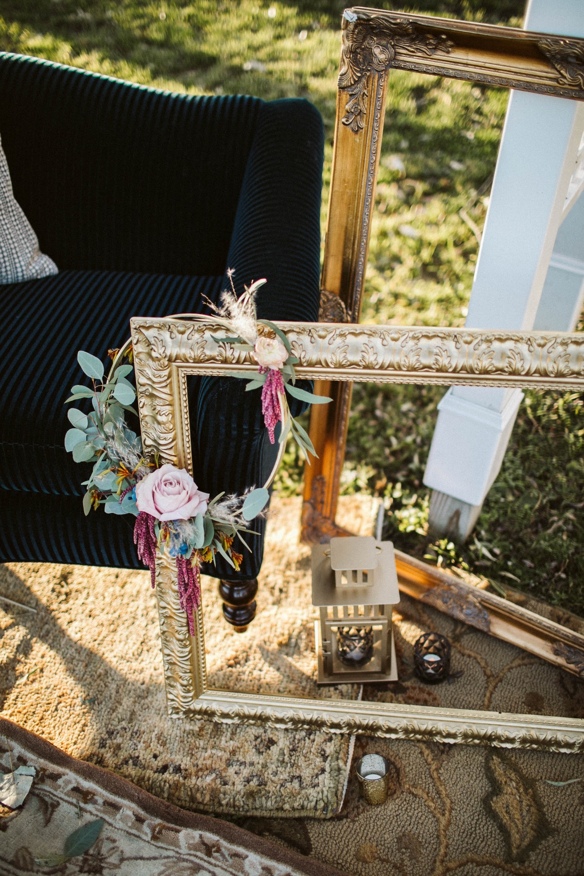 Elegant frames and chair with floral arrangement outdoors