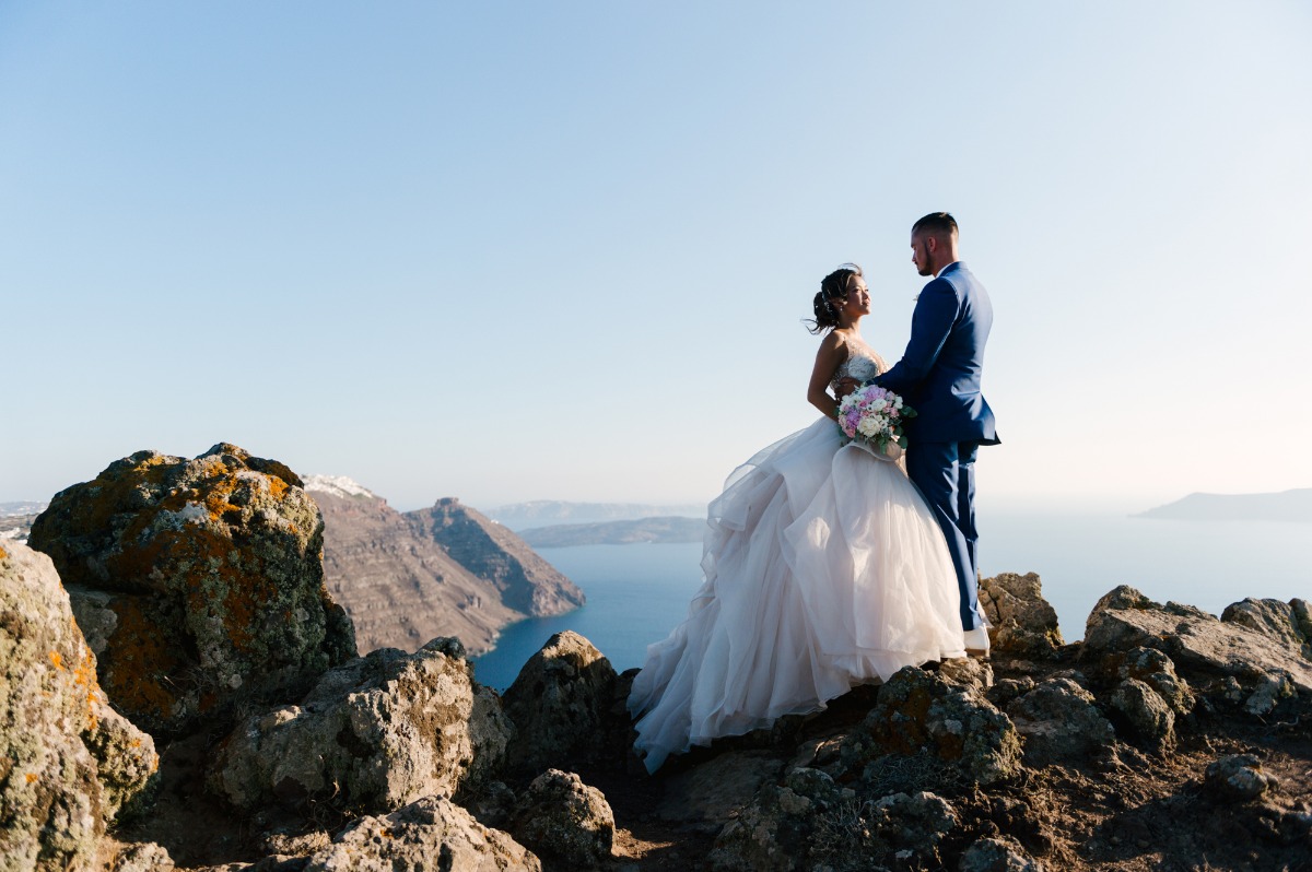 Wedding couple on a mountain overlooking the ocean on a sunny day