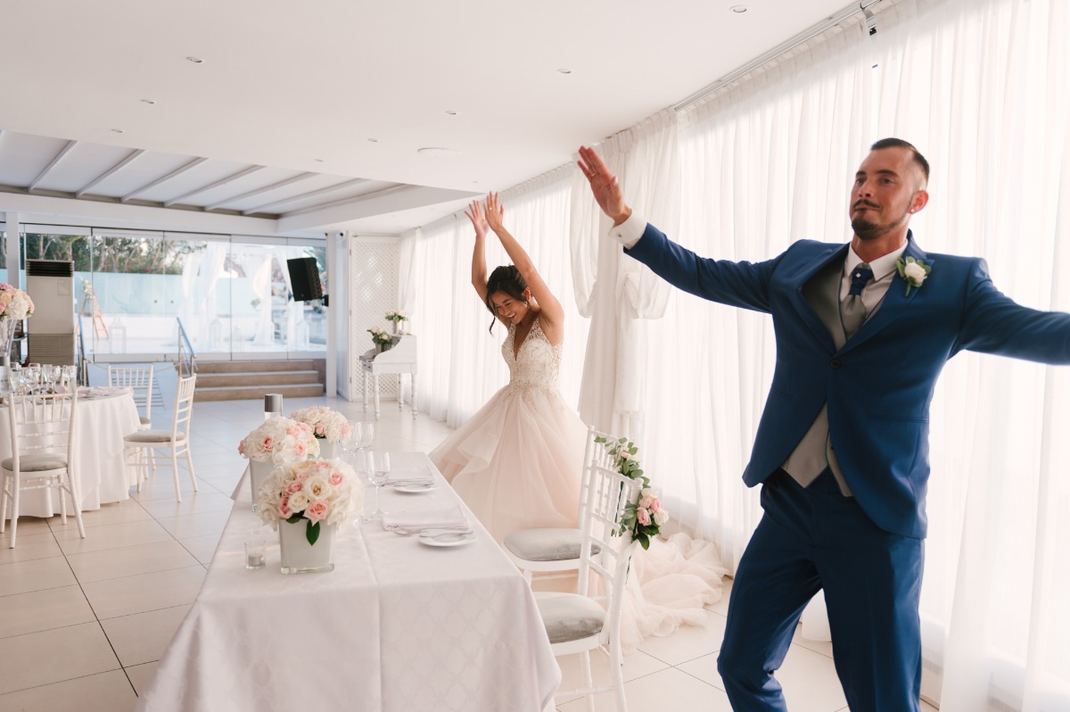 Happy bride and groom dancing joyfully at their wedding reception