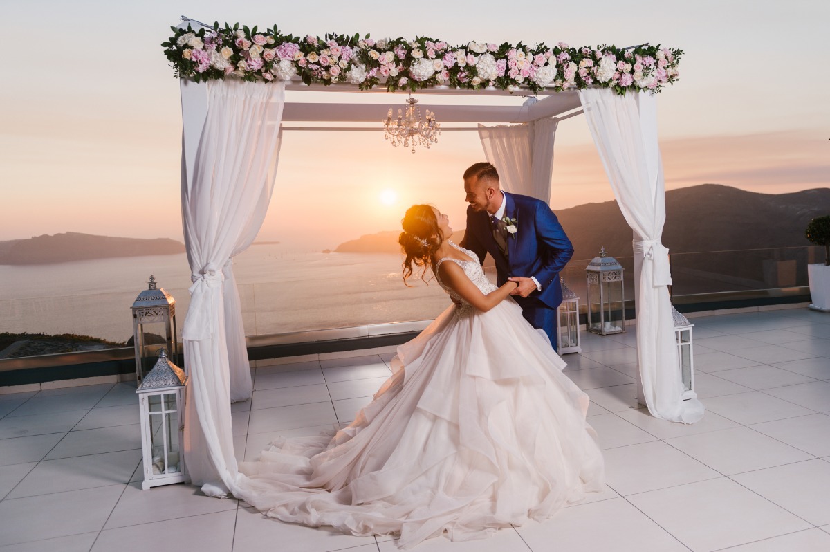 Romantic wedding couple dancing at sunset over the sea