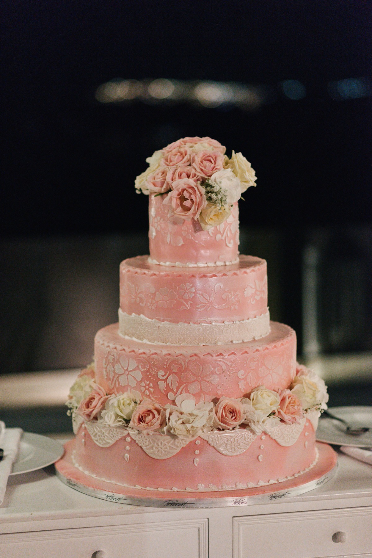 Elegant pink wedding cake with floral decorations and delicate details