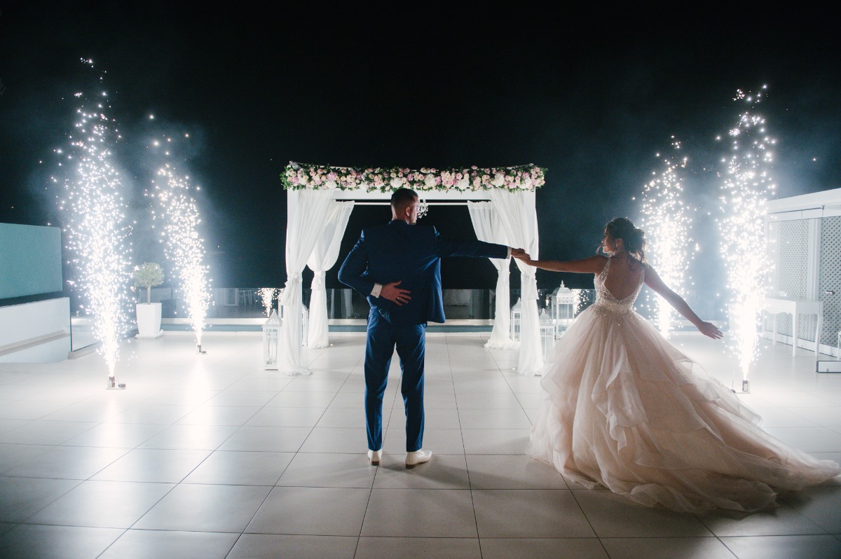 Romantic wedding couple dancing under fireworks at night