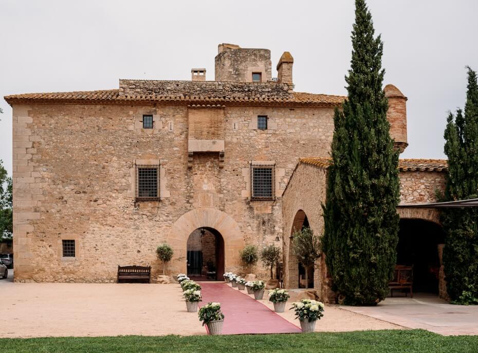 Historic stone building with arched entryway and flowers