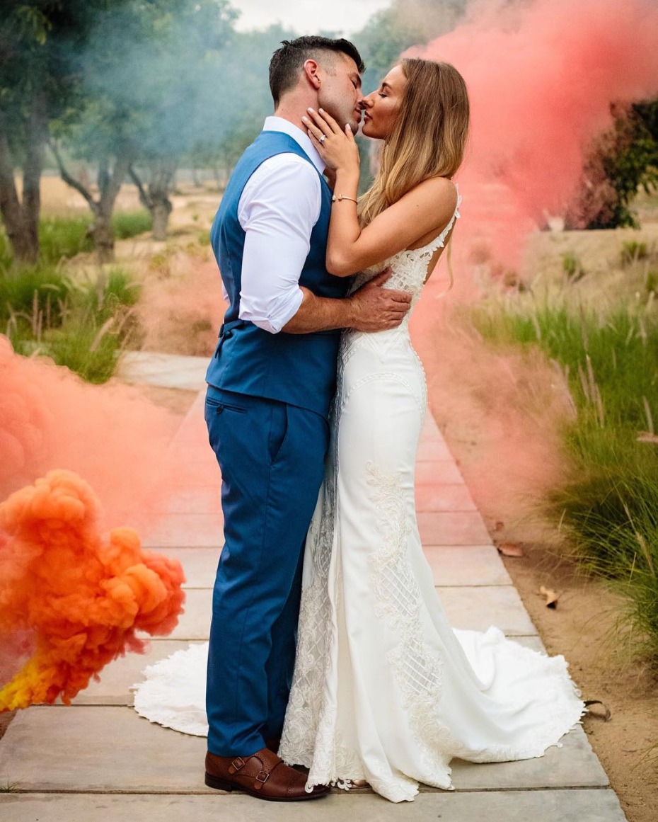 Colorful smoke bomb couple kissing at Mexico wedding