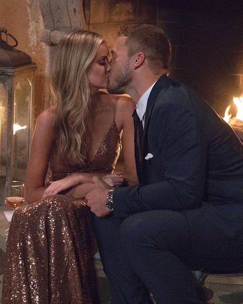 Couple sharing a romantic kiss in front of a fireplace