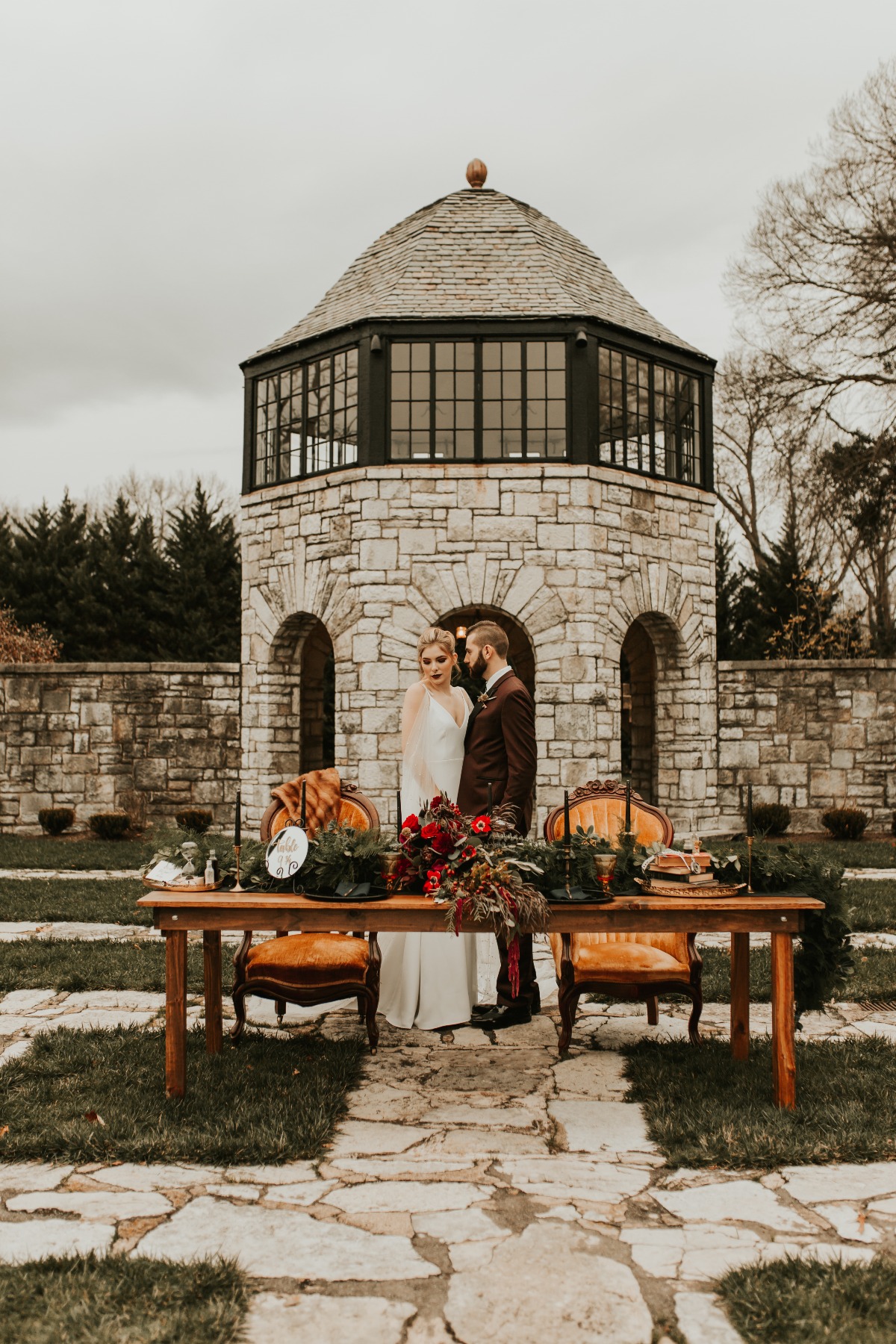 Bride and groom by a decorated wedding table outdoors