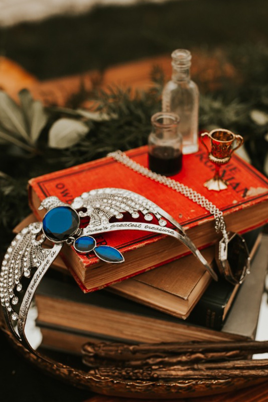 Still life of a jewel crown, potion bottles and books