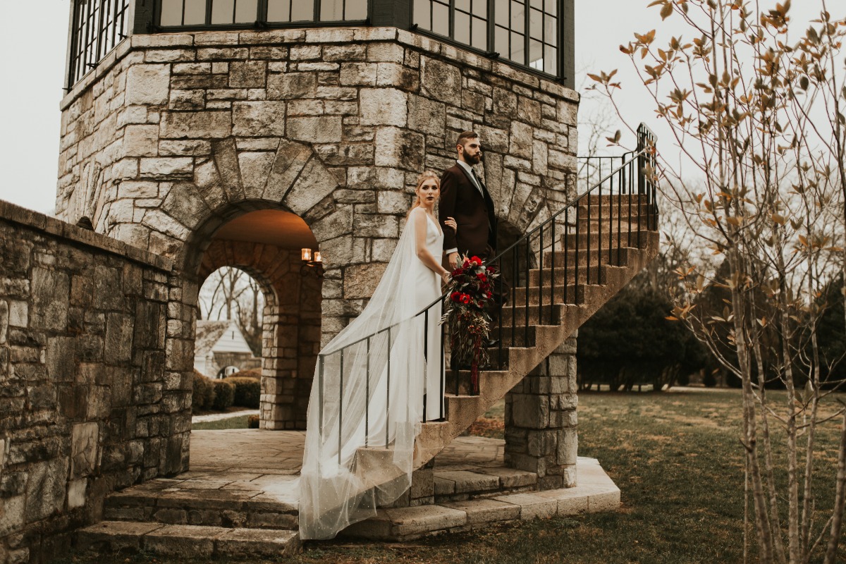 Elegant couple poses on stone tower wedding stairs