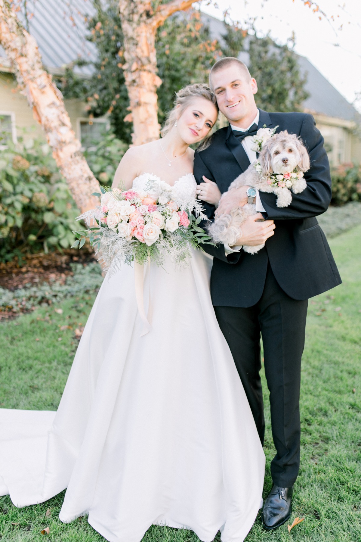Happy couple with dog and bouquet on their wedding day