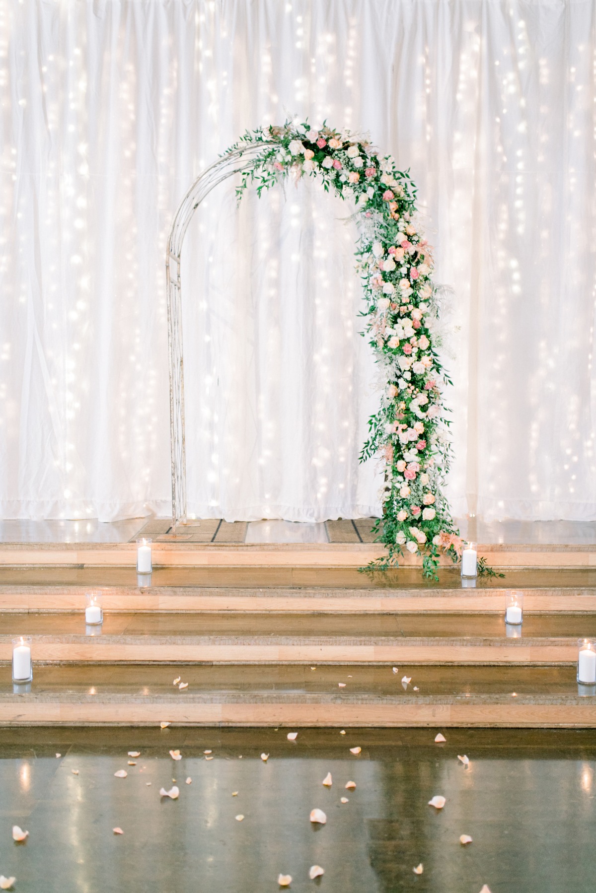 Elegant floral wedding arch with candles and petals