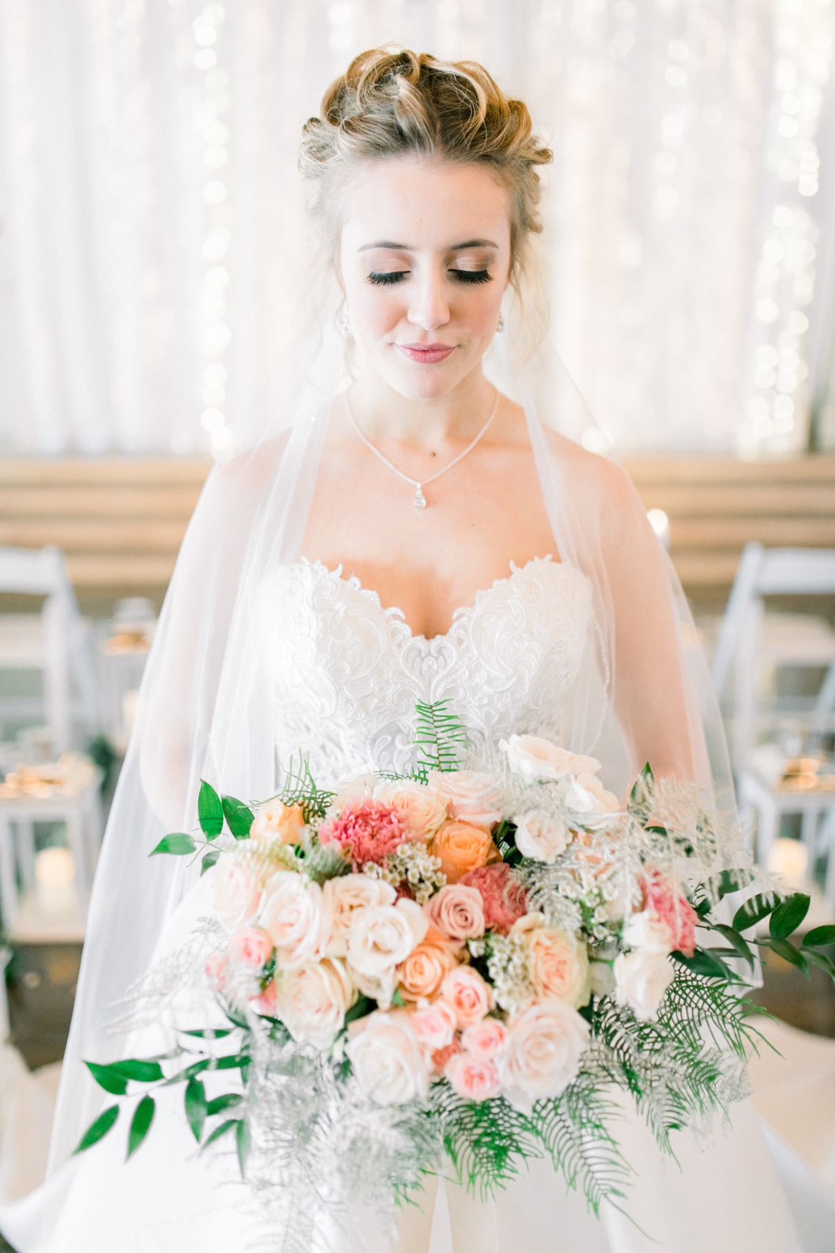 Bride holding a beautiful peach and white wedding bouquet