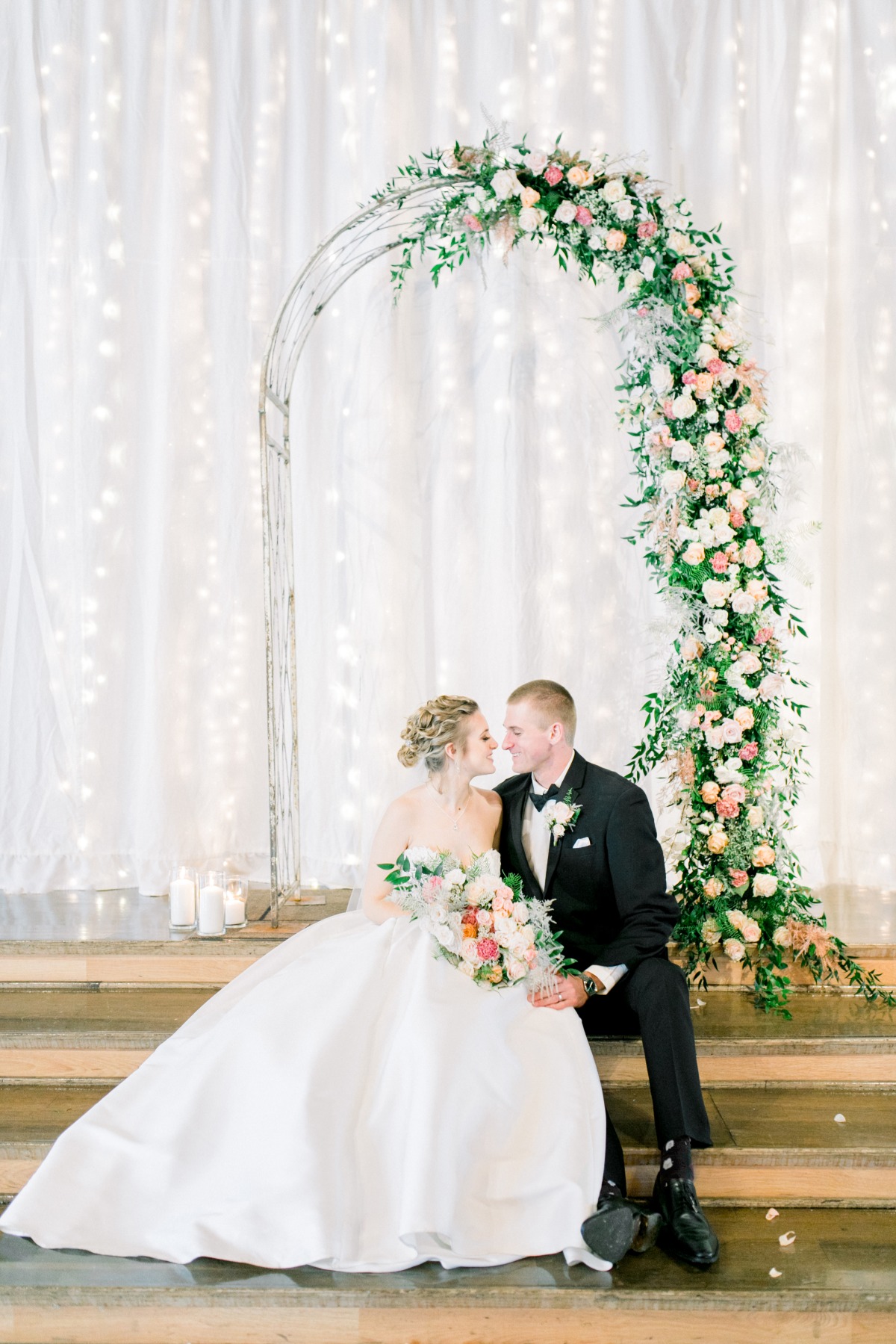 Romantic bride and groom with flower arch wedding portrait