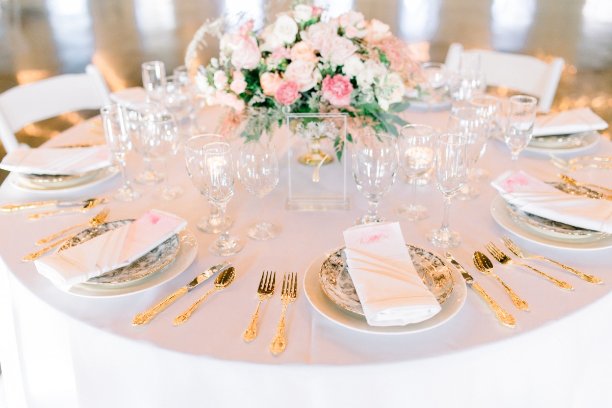Elegant wedding table with gold cutlery and floral centerpiece
