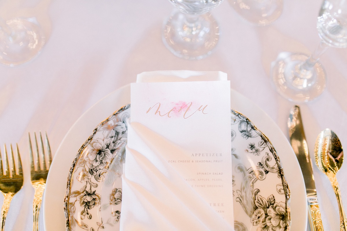 Elegant wedding table setting with menu and gold cutlery