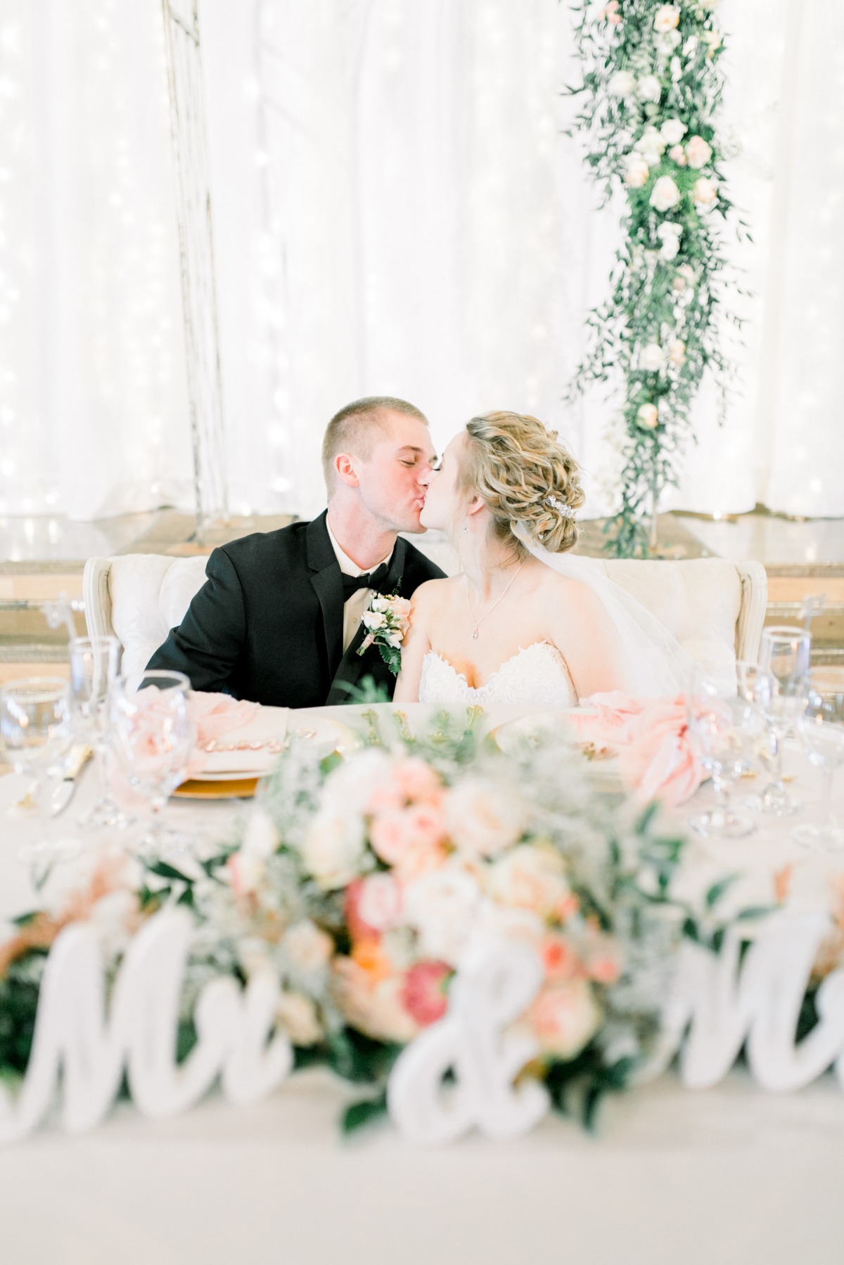 Happy wedding kiss of bride and groom at reception