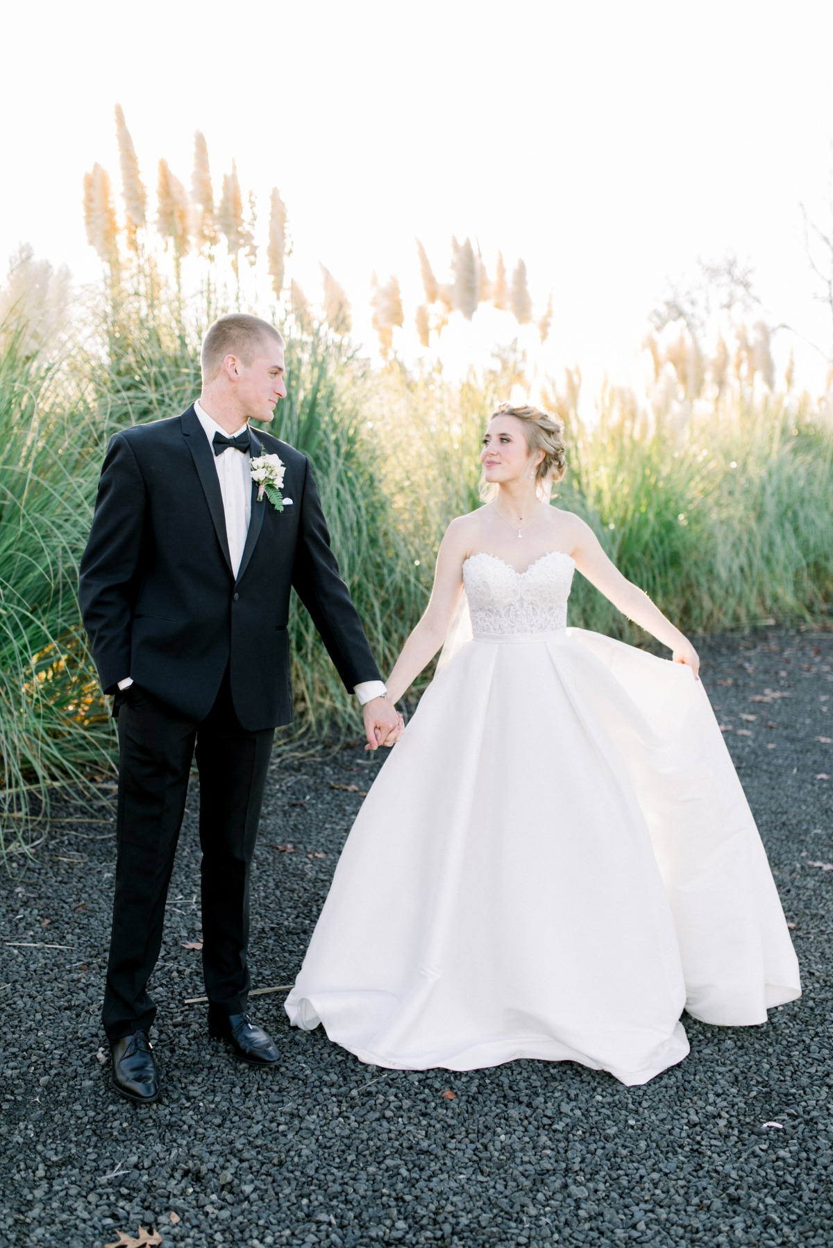 Romantic bride and groom hold hands on wedding day