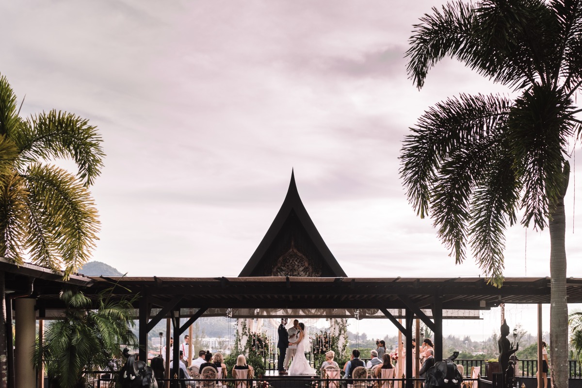 Thai wedding ceremony under a pavilion with palm trees