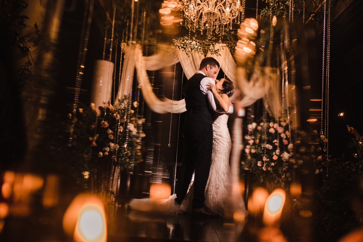 Bride and groom share a kiss at their wedding reception