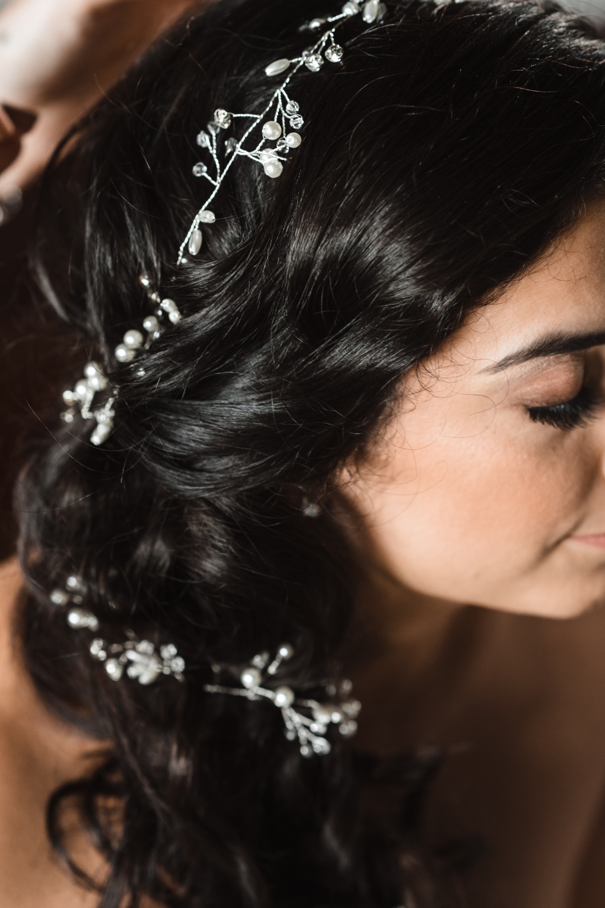 Dark wavy hair styled with pearl beaded accessories