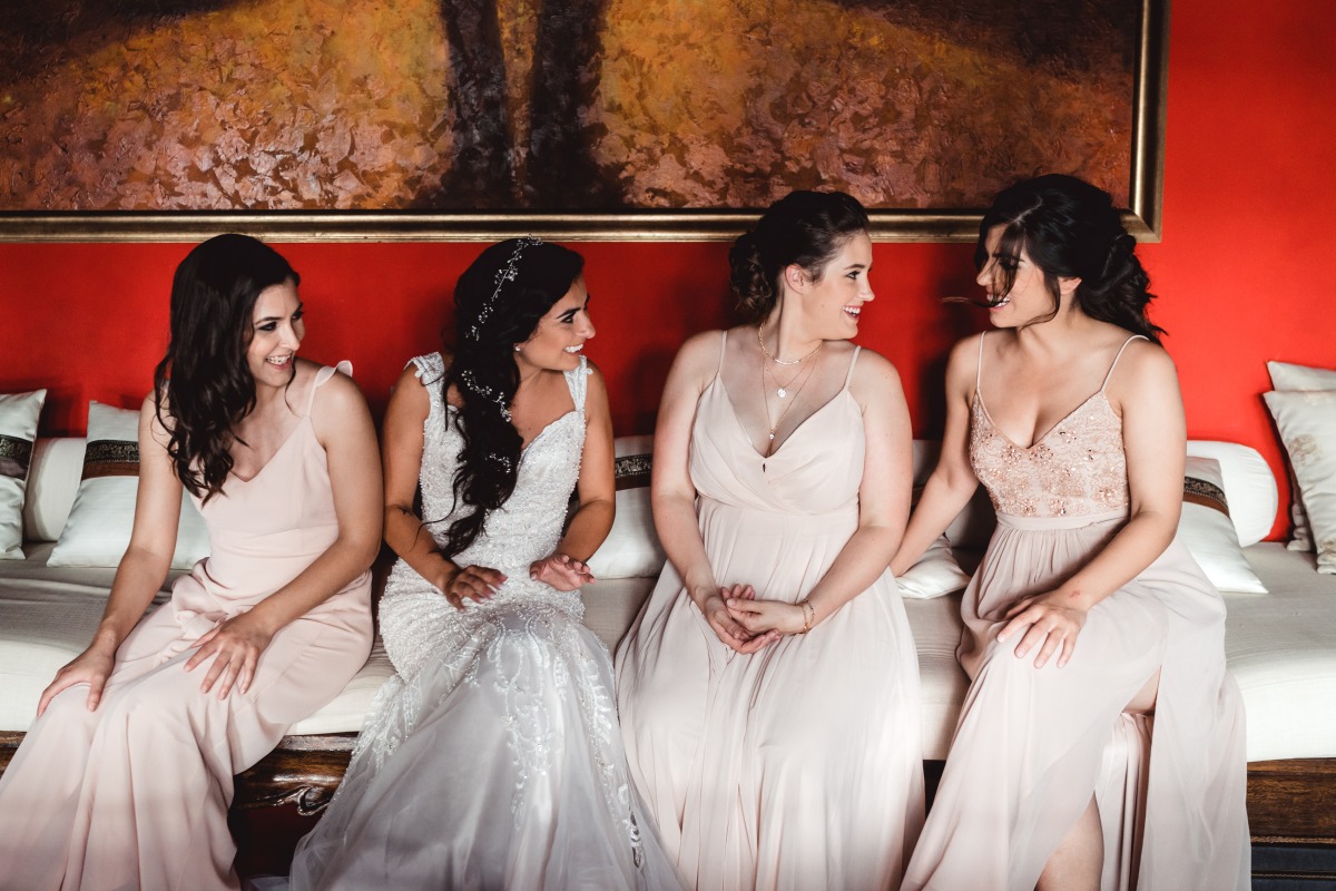 Bride and bridesmaids in dresses smiling on wedding day