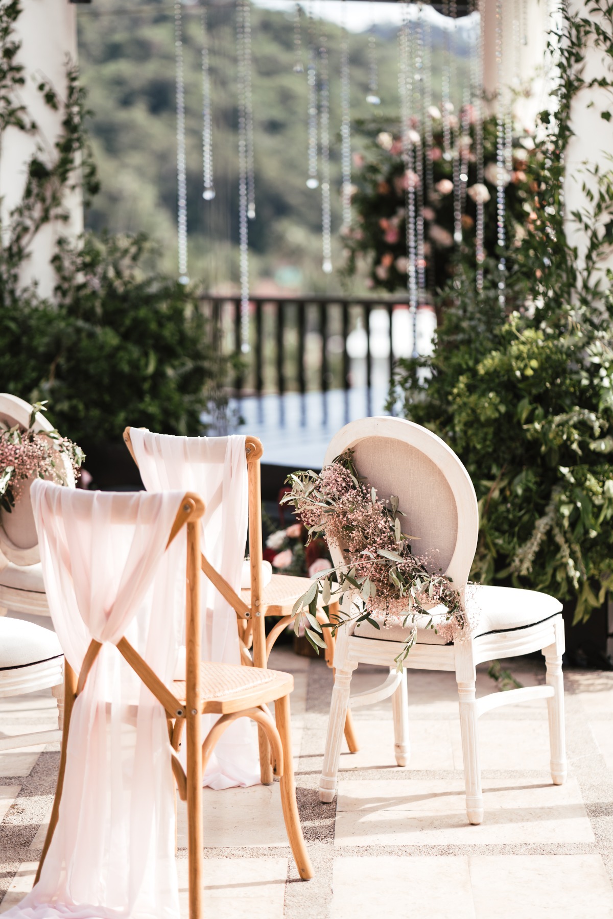 Wedding chairs decorated with flowers and sheer fabric