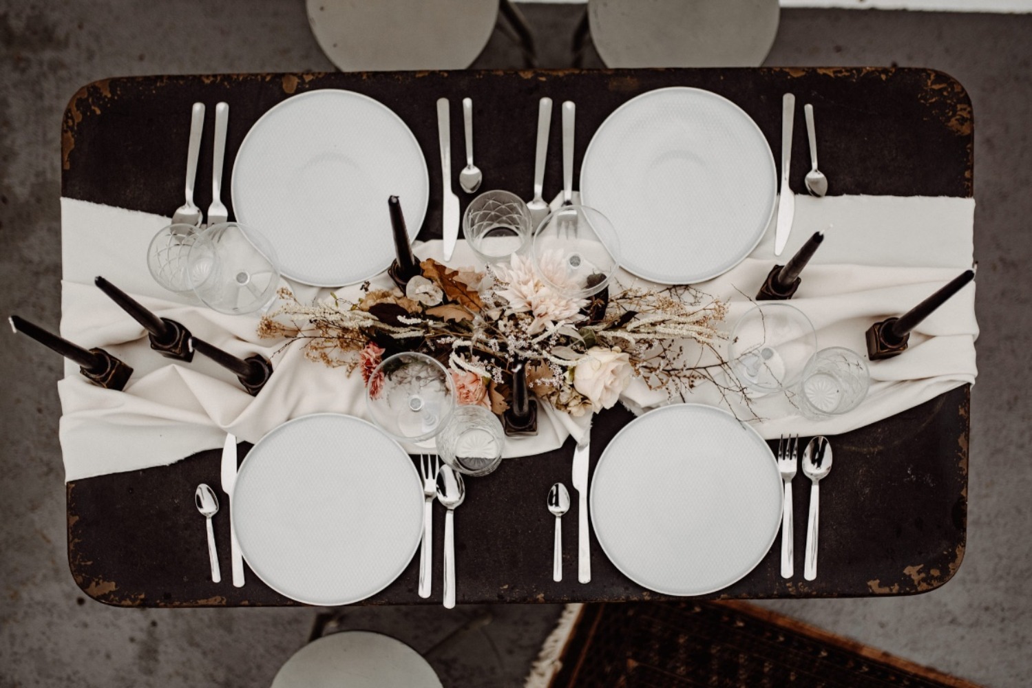 Elegant table setting with white plates, silverware, and flowers