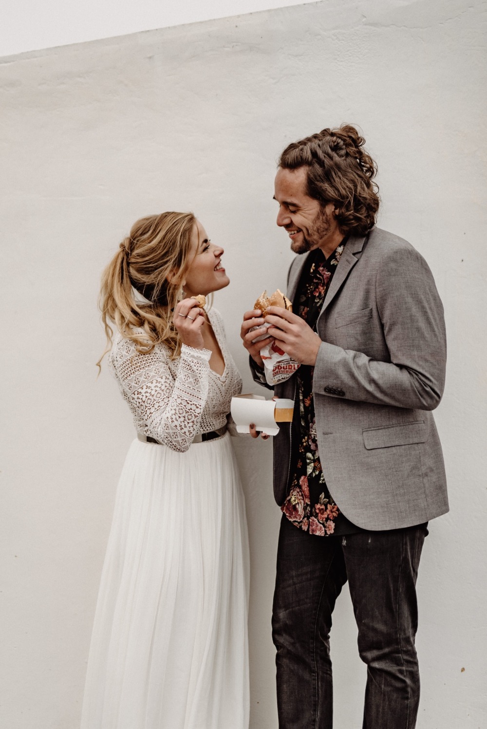 Happy couple enjoying burgers on their wedding day