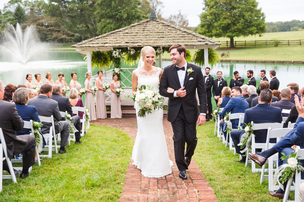 Bride and groom walk down aisle at outdoor wedding
