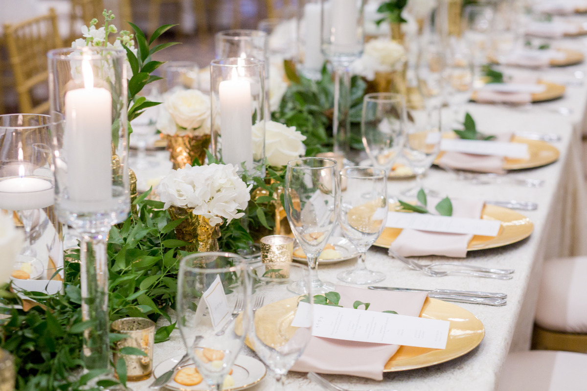 Elegant wedding table setting with gold chargers flowers