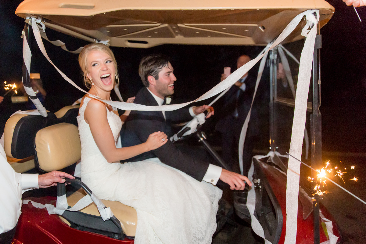 Newlyweds joyfully drive off in decorated golf cart