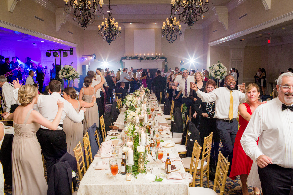 Wedding guests dance joyfully at reception with live band