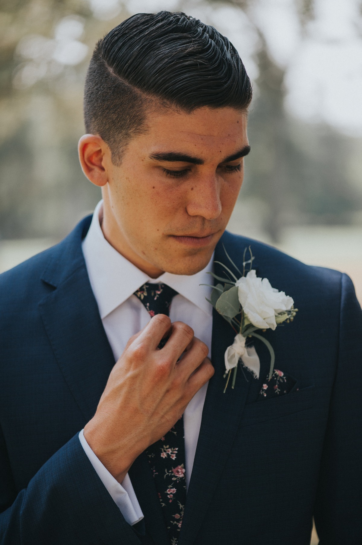 groom in navy suite with floral tie and pocket square