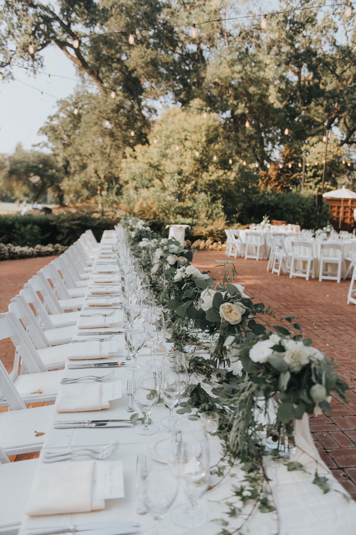 wedding party family style seating with white and greenery floral decor