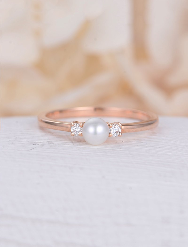 Rose gold ring with pearl and diamond side stones