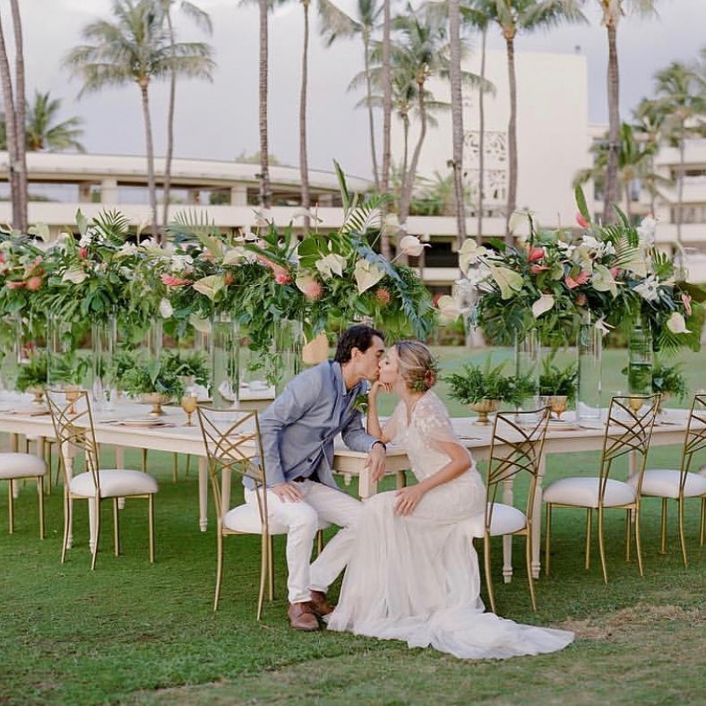 Bride and groom kissing at tropical wedding reception