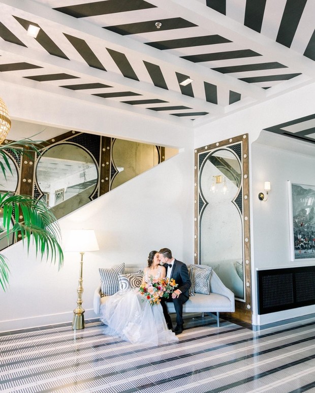 Bride and groom kissing in stylish black and white hotel