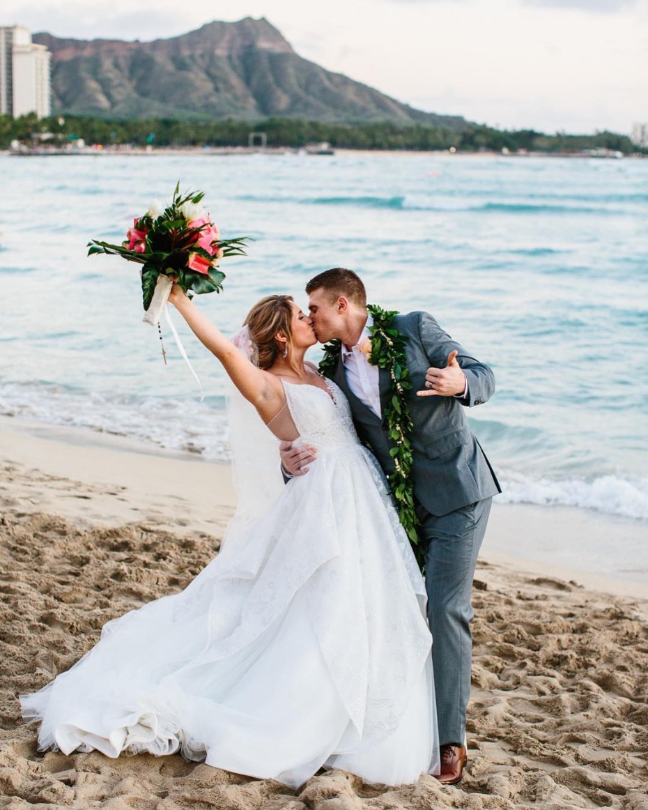 Bride and groom kissing on beach wedding