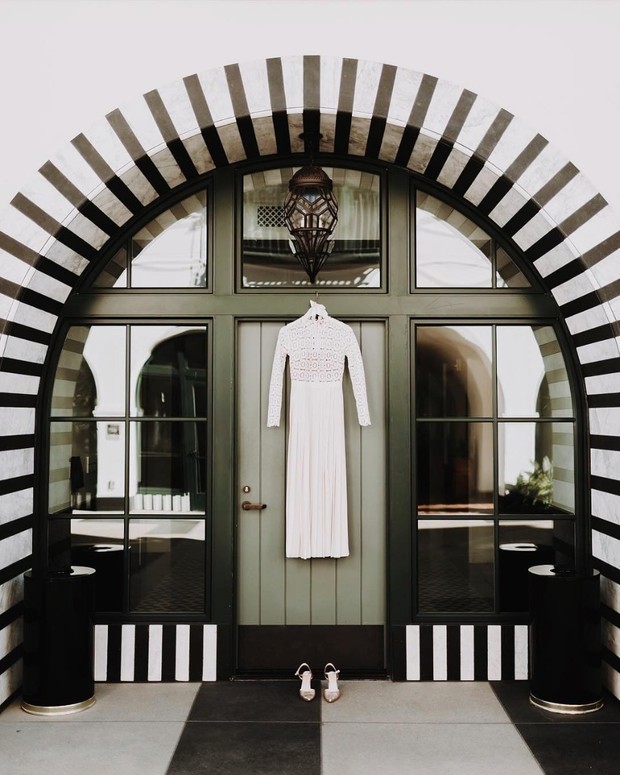 Elegant wedding dress hanging on a decorative door