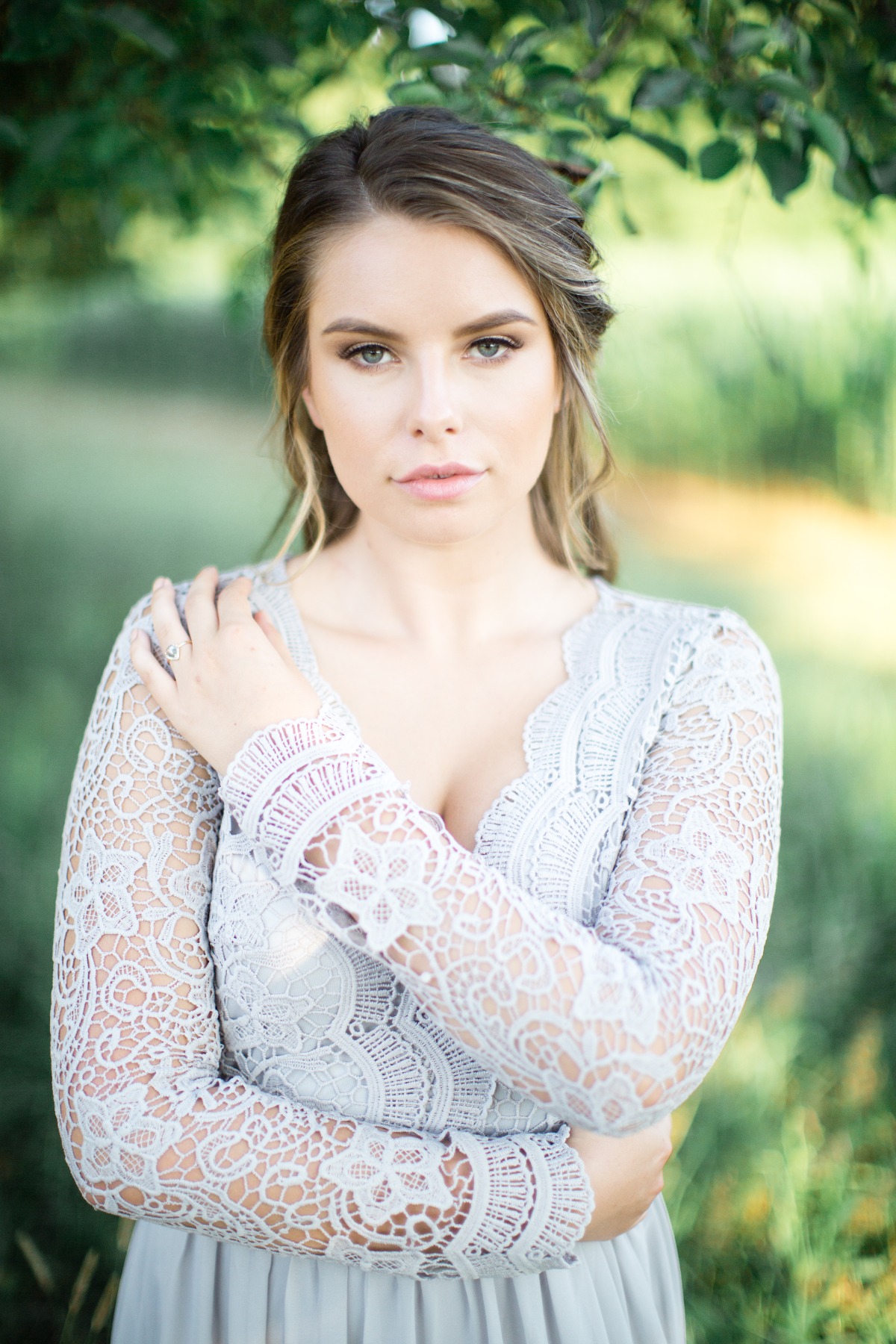 Elegant woman in lace dress posing in nature with thoughtful look