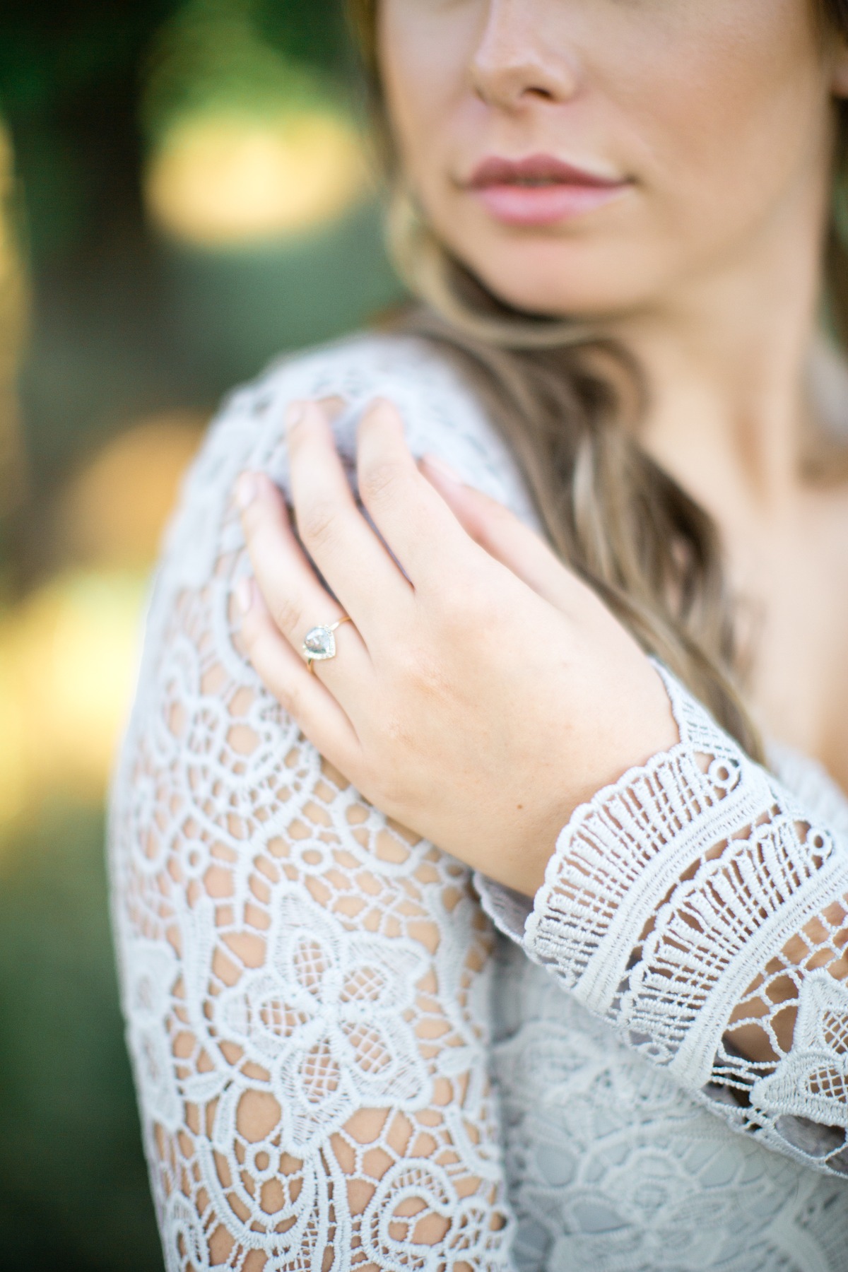 Elegant woman with a diamond ring and lace dress detail