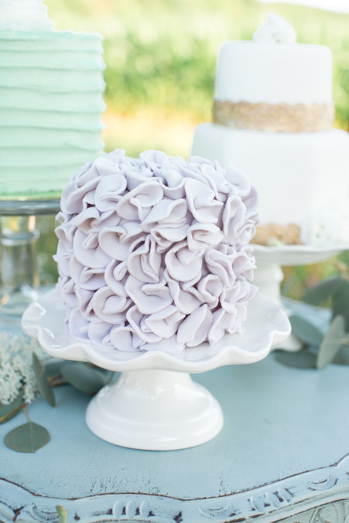 Small wedding cake decorated with layered petals in soft purple